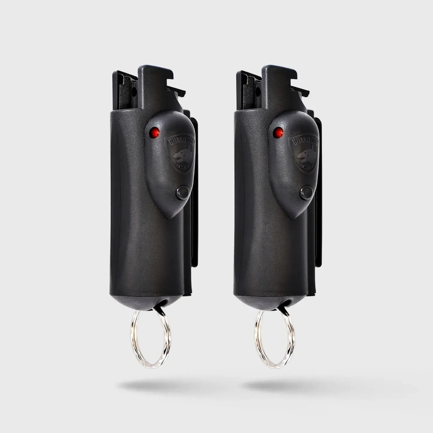 Two black pepper spray canisters with keychain attachments.