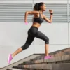 Woman running up outdoor stairs in athletic wear.