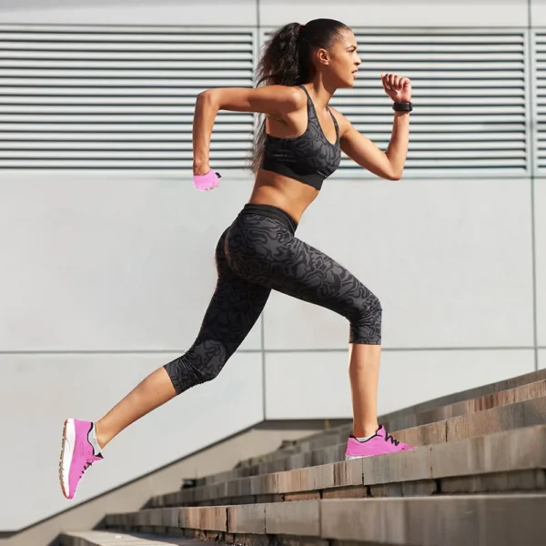 Woman running up outdoor stairs in athletic wear.